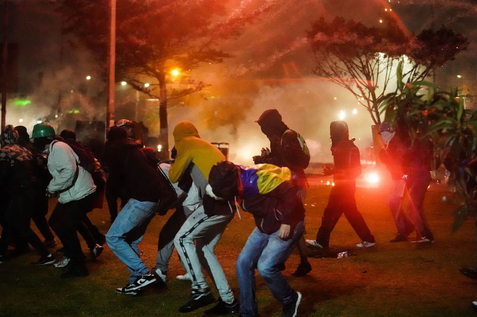 Demonstrators take cover while clashing with police during a protest in Bogota, Colombia, on May 28, 2021. MUST CREDIT: Bloomberg photo by Nathalia Angarita.