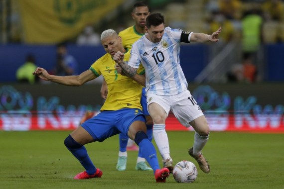 Lionel Messi (R) vies with Brazil's Richarlison (L).