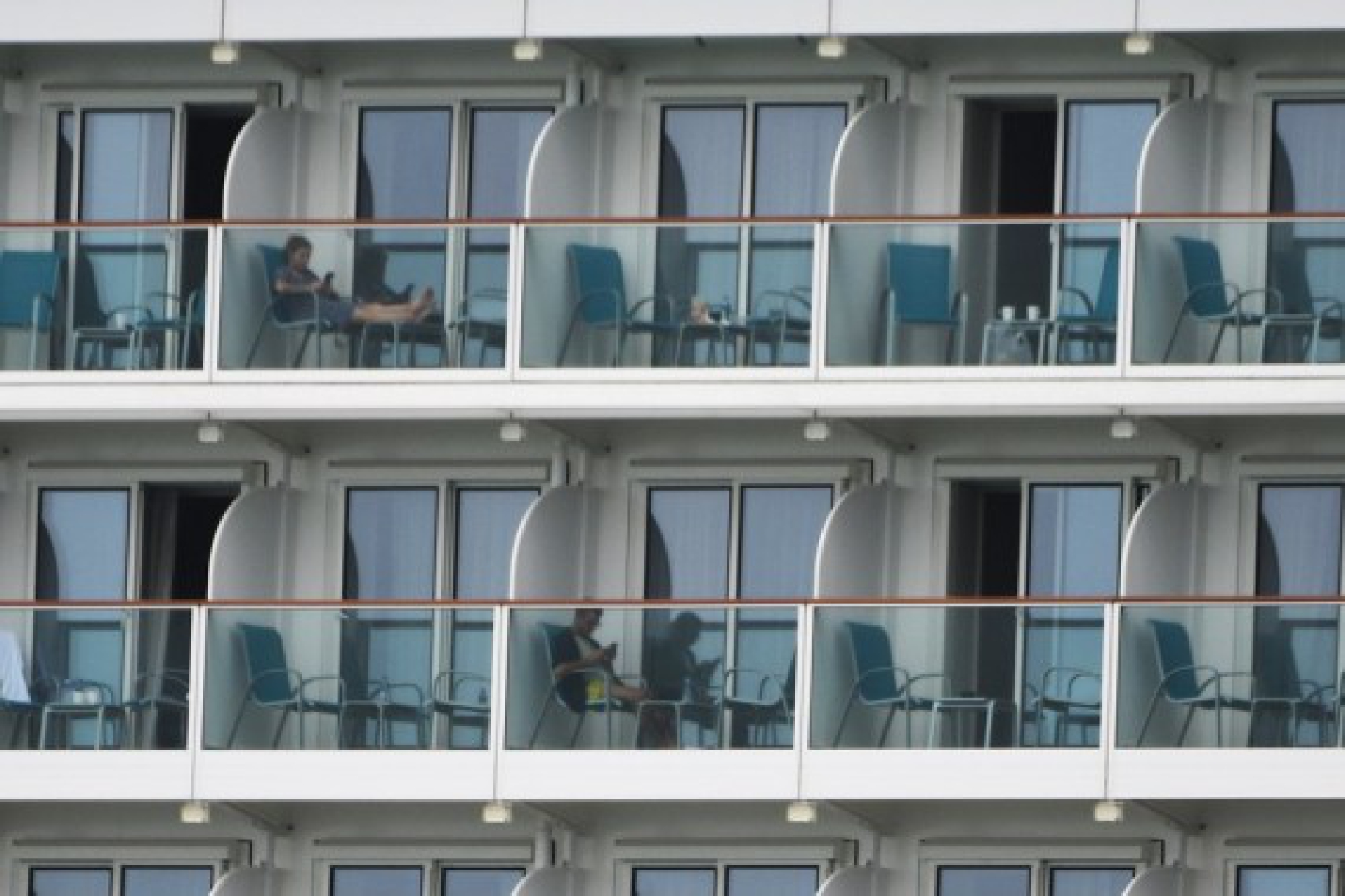 Passengers are seen aboard the cruise ship World Dream docked at the Marina Bay Cruise Centre in Singapore, July 14, 2021.