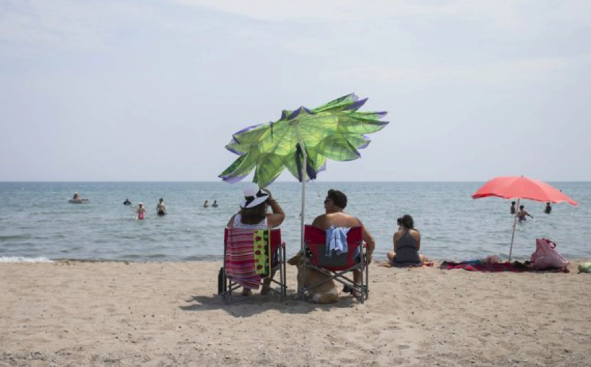 People enjoy leisure time on a beach of Lake Ontario during a heat wave in Toronto, Canada,
