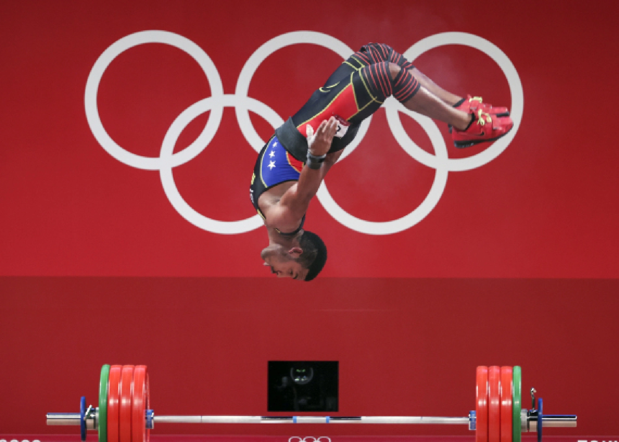Julio Ruben Mayora Pernia of Venezuela somersaults during the men's 73kg weightlifting event of the Tokyo 2020 Olympic Games in Tokyo, Japan, July 28, 2021.