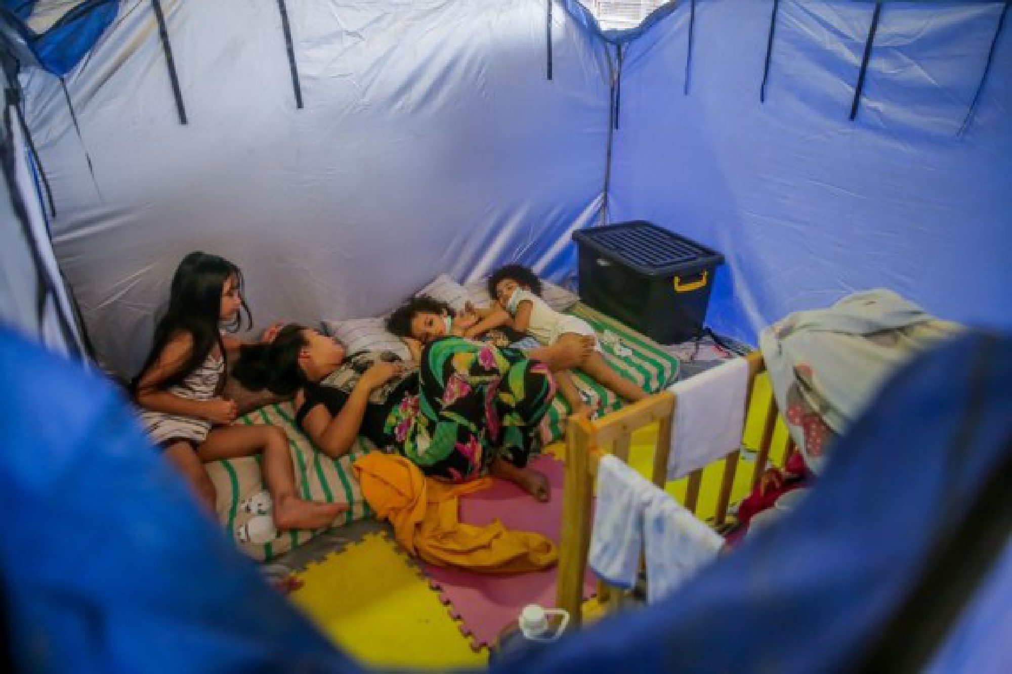 A family is seen inside an emergency modular tent as they take shelter at an evacuation center in Marikina City, the Philippines on July 24, 2021.
