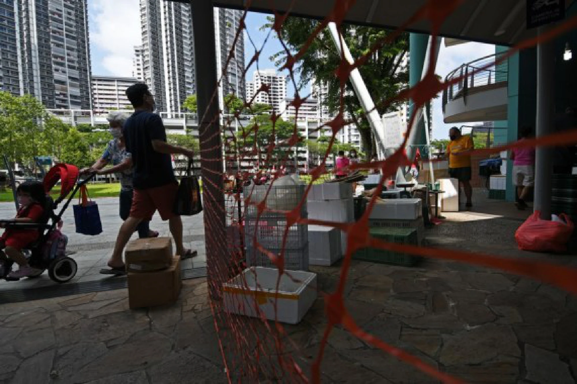 People wearing masks buy groceries in a temporarily-enclosed market in Singapore's Toa Payoh on July 27, 2021.