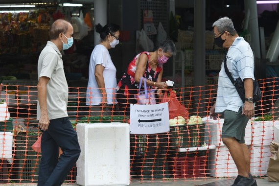 People wearing masks buy groceries in a temporarily-enclosed market in Singapore's Toa Payoh on July 27, 2021.