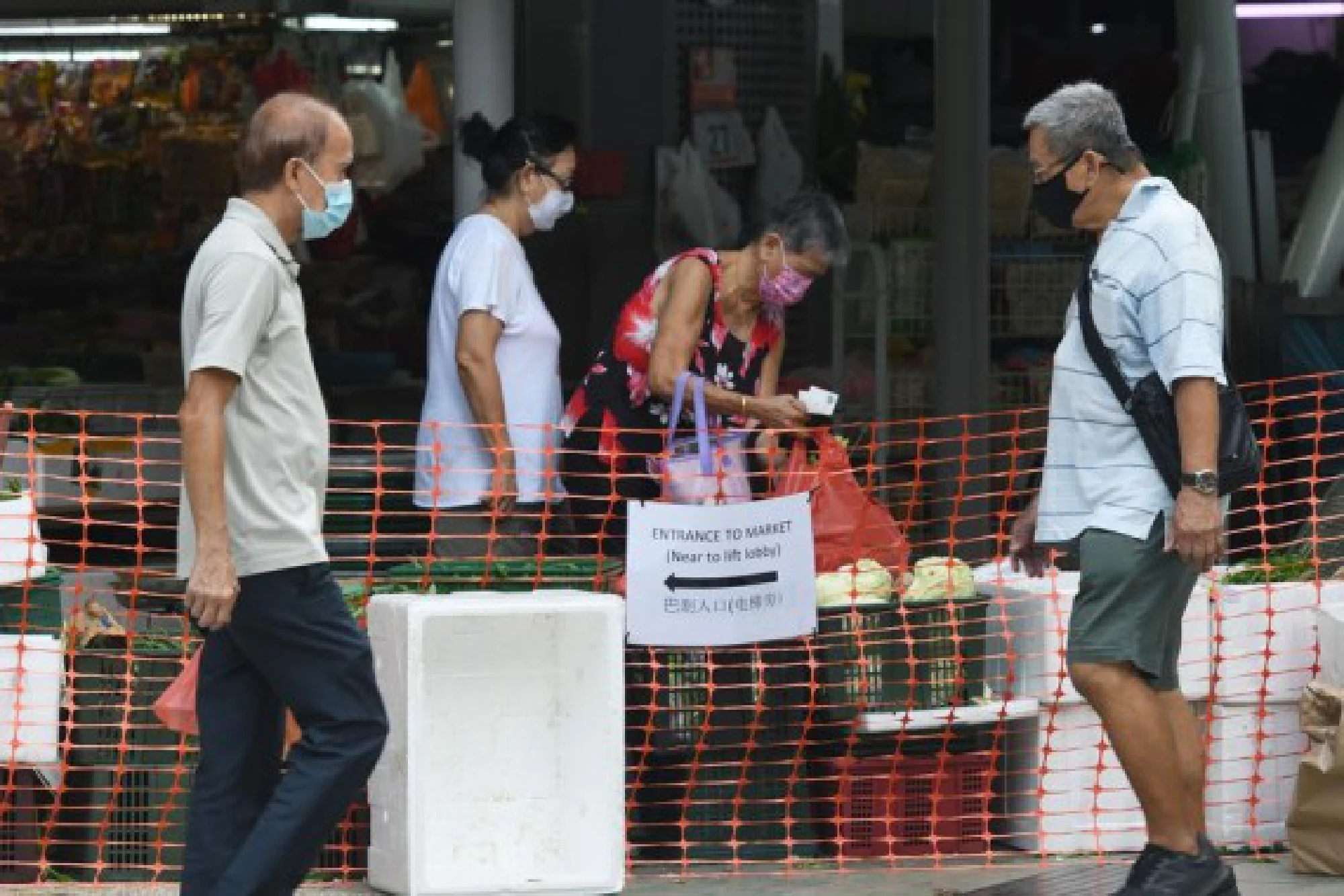 People wearing masks buy groceries in a temporarily-enclosed market in Singapore's Toa Payoh on July 27, 2021.