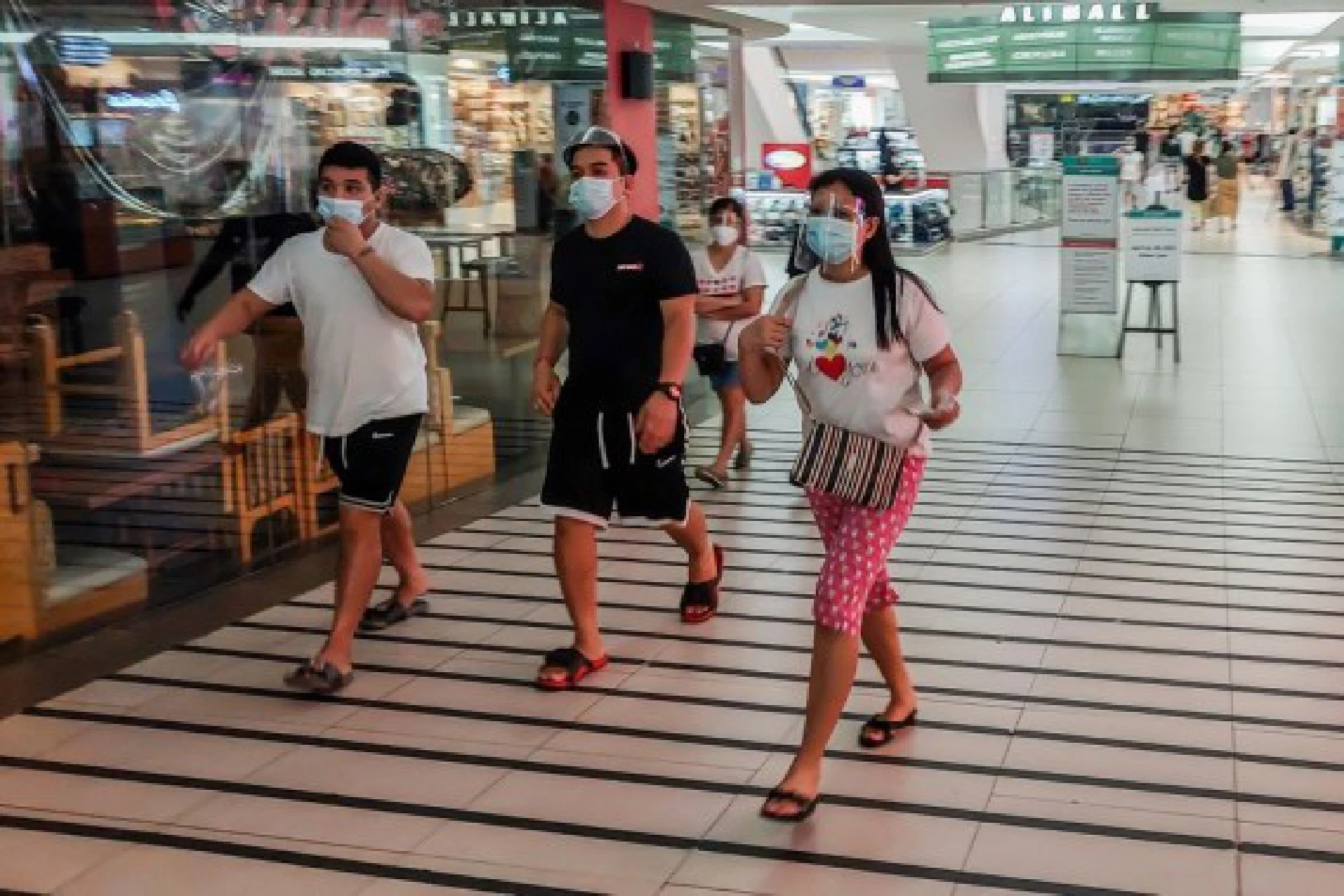 People wearing protective masks are seen inside a mall in Manila, the Philippines