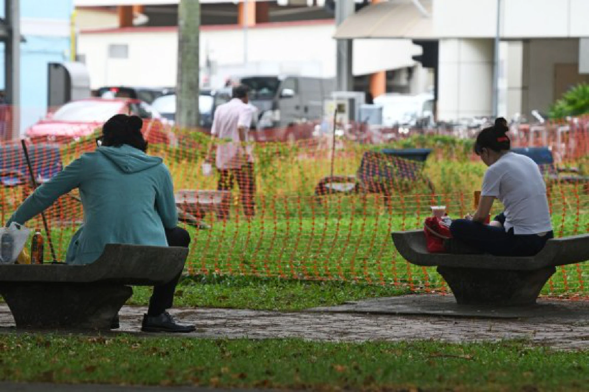 People have their meal on park benches in Singapore's Toa Payoh on July 27, 2021. 