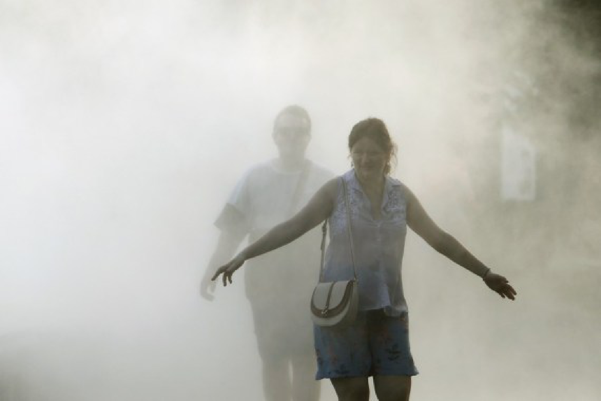 People cool off at a fountain during a hot day in downtown Bucharest, Romania, on July 28, 2021.