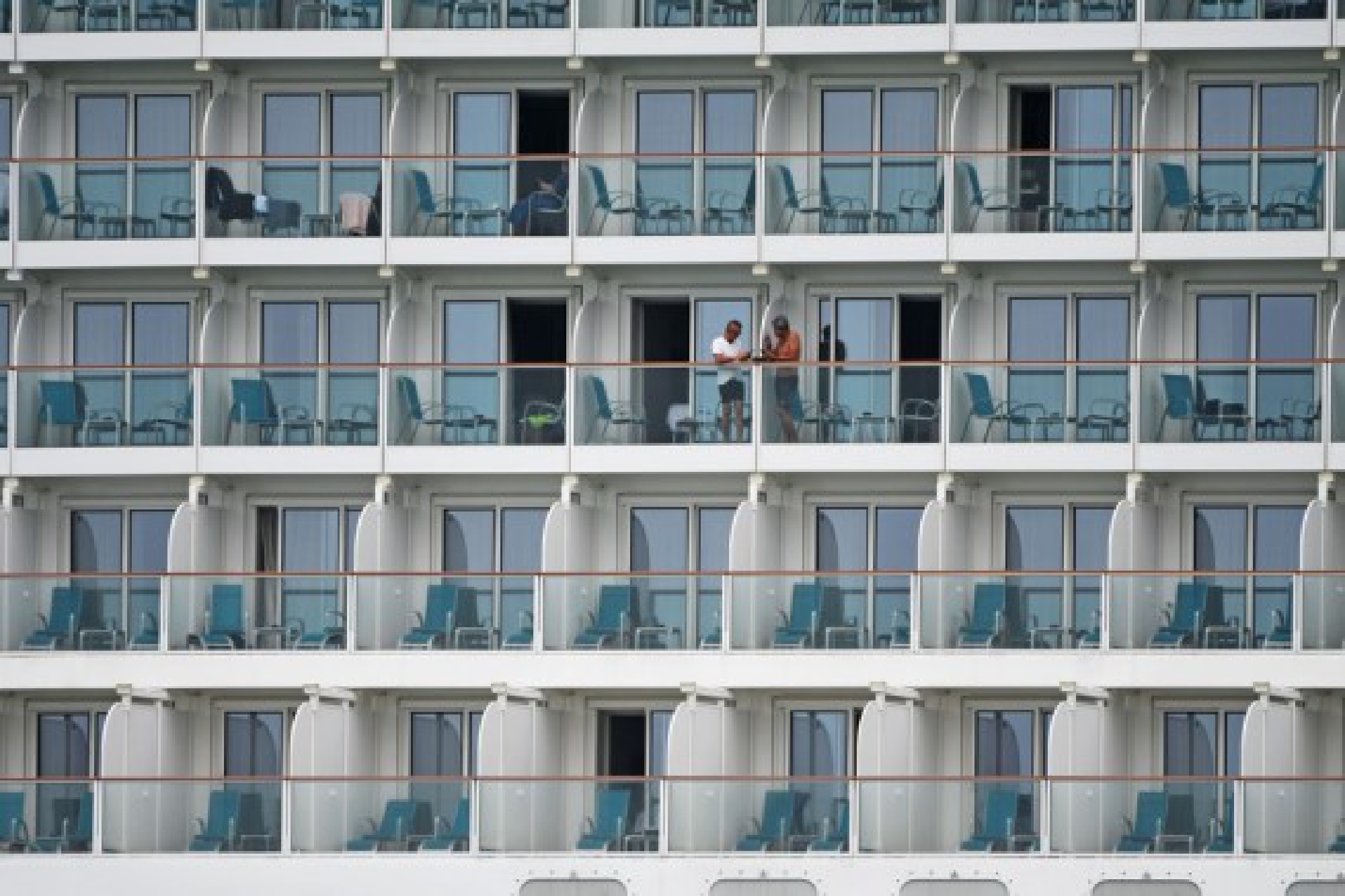 Passengers are seen aboard the cruise ship World Dream docked at the Marina Bay Cruise Centre in Singapore, July 14, 2021.