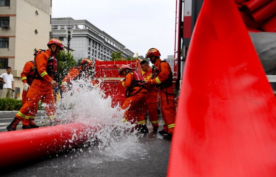 Firefighters pump rainwater out of a road in Zhengzhou, capital of central China's Henan Province,