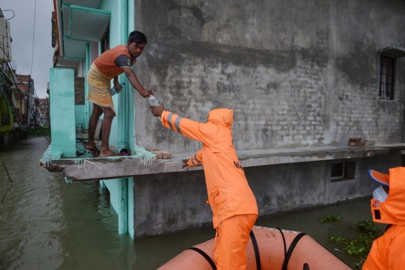 Members of the National Disaster Response Force (NDRF) distribute relief supplies among flood-affected people in Prayagraj district in India's northern state of Uttar Pradesh, Aug. 10, 2021