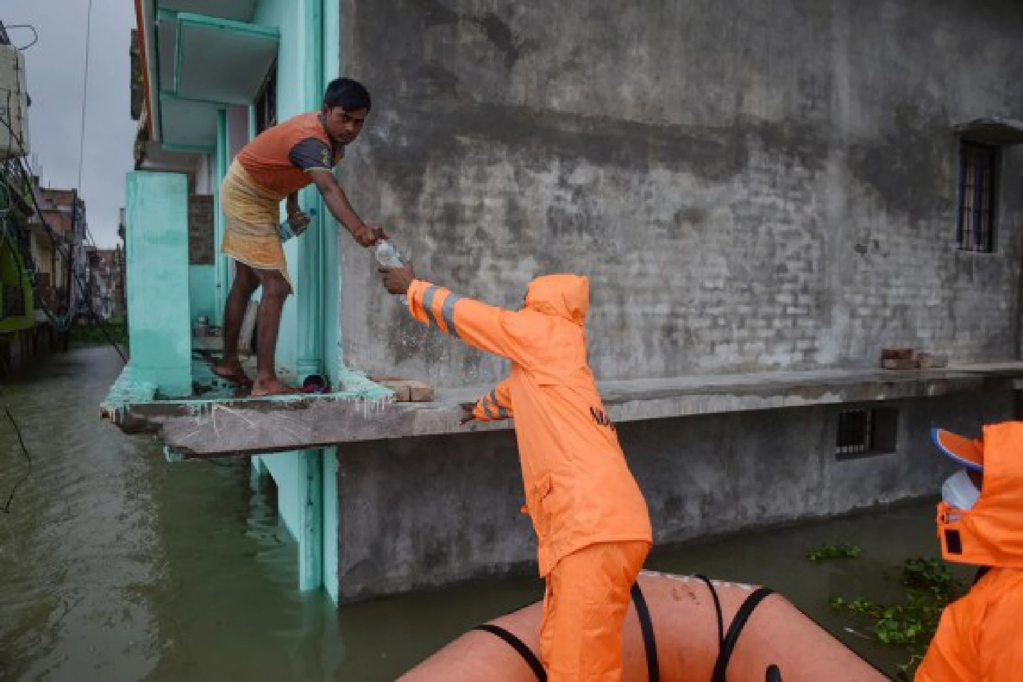 Members of the National Disaster Response Force (NDRF) distribute relief supplies among flood-affected people in Prayagraj district in India's northern state of Uttar Pradesh, Aug. 10, 2021