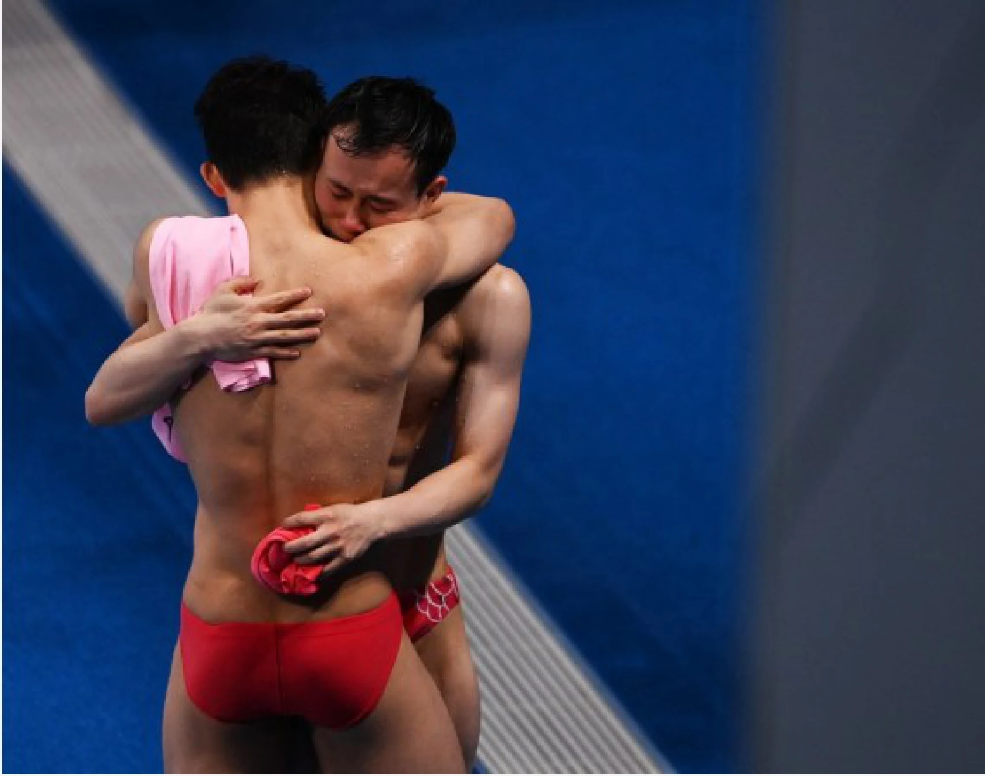 Xie Siyi (Rear) and Wang Zongyuan of China hug each other after the men's 3m springboard final of diving at the Tokyo 2020 Olympic Games in Tokyo, Japan, Aug. 3, 2021. 