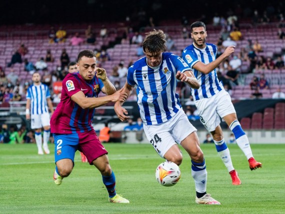 Barcelona's Sergino Dest (L) vies with Real Sociedad's Robin le Normand during their Spanish La Liga match between FC Barcelona and Real Sociedad in Barcelona, Spain, on Aug. 15, 2021.