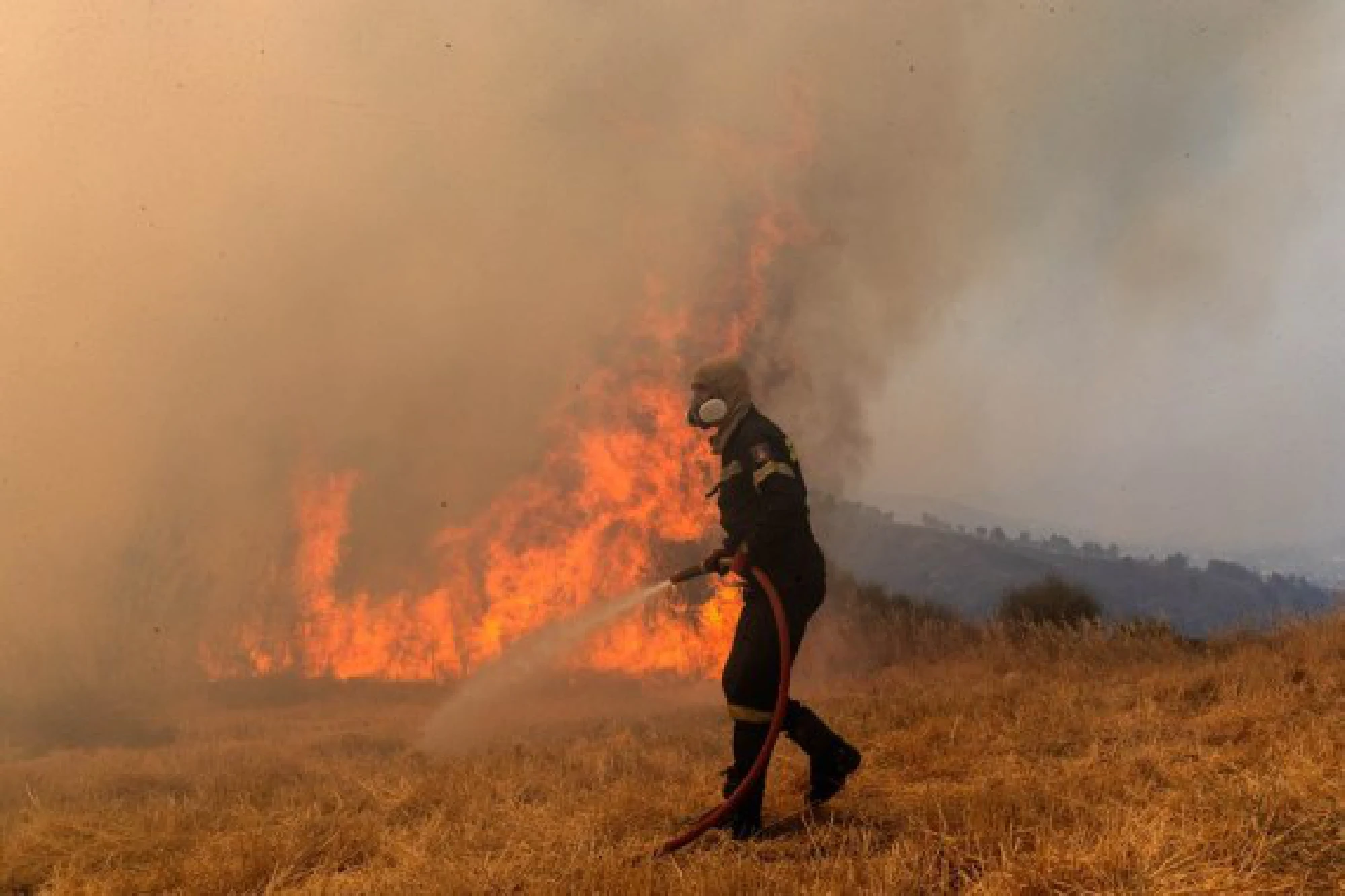 A firefighter tries to put out a fire in Afidnes, some 30 kilometers away from the Greek capital of Athens, on Aug. 6, 2021. 