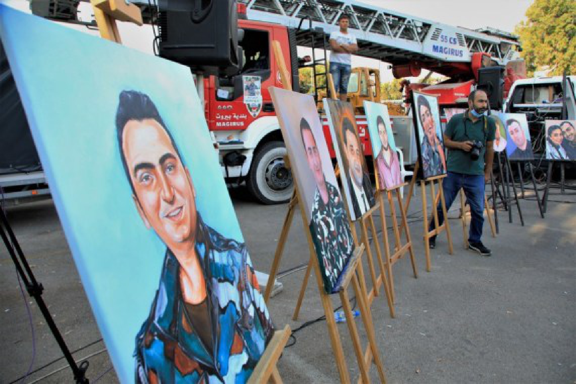 Portraits are displayed at an art exhibition commemorating the martyrdom of 10 firefighters upon the first anniversary of the Beirut port blast in Beirut, Lebanon, Aug. 3, 2021.