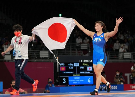 Yukako Kawai (R) of Japan celebrates with her coach after winning the wrestling women's freestyle 62kg final at the Tokyo 2020 Olympic Games in Chiba, Japan, Aug. 4, 2021. 