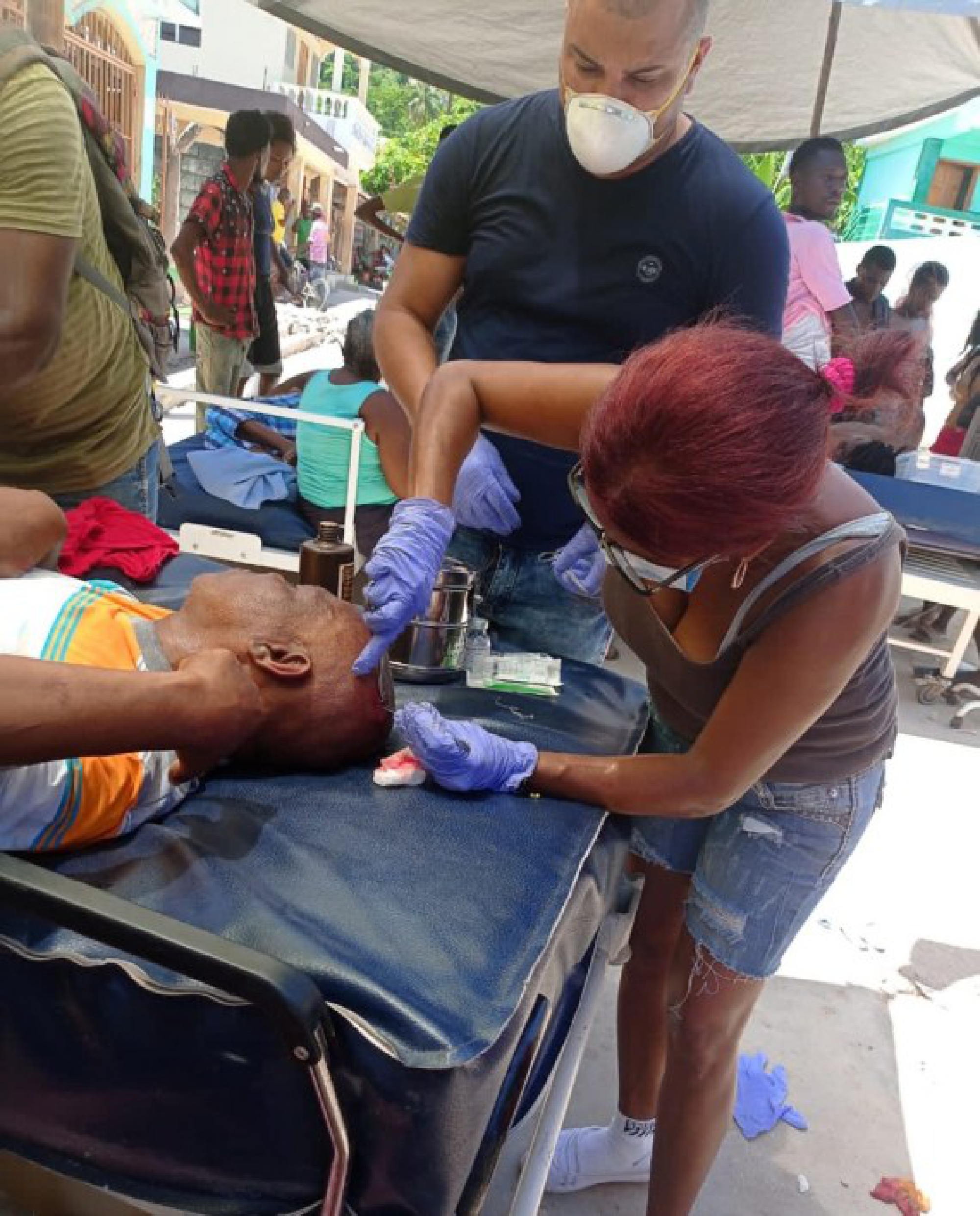 Photo taken with a mobile device shows members of the Cuban Medical Brigade helping an injured person after an earthquake in Jeremie, Haiti, Aug. 14, 2021.