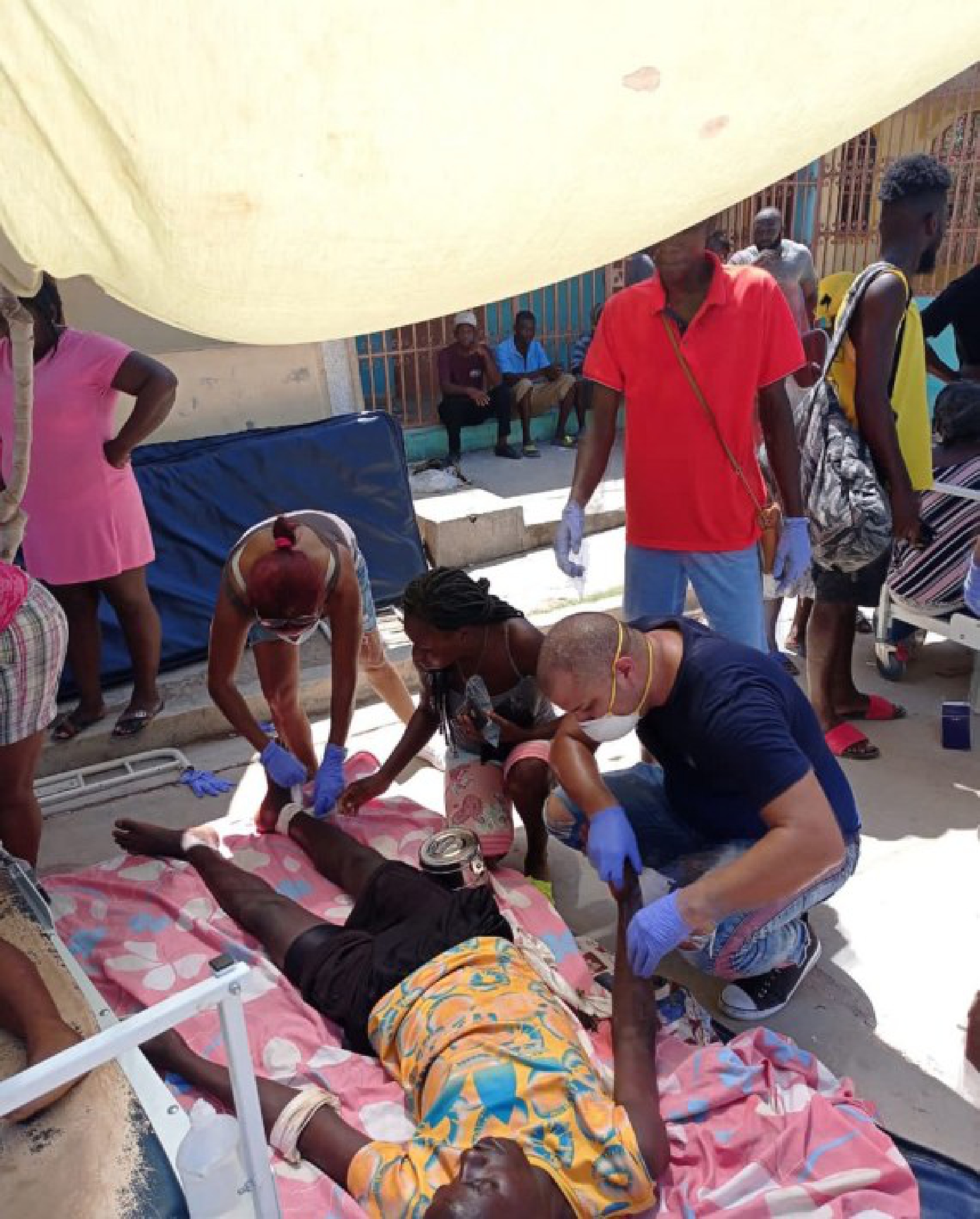 Photo taken with a mobile device shows members of the Cuban Medical Brigade helping an injured person after an earthquake in Jeremie, Haiti, Aug. 14, 2021.