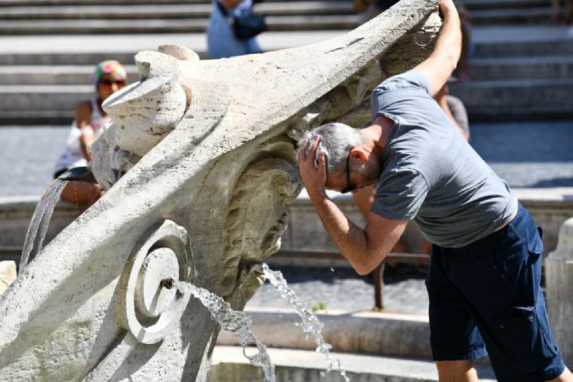  A man refreshes himself with the water of the Barcaccia Fountain in the Piazza di Spagna in Rome, Italy, Aug. 12, 2021.