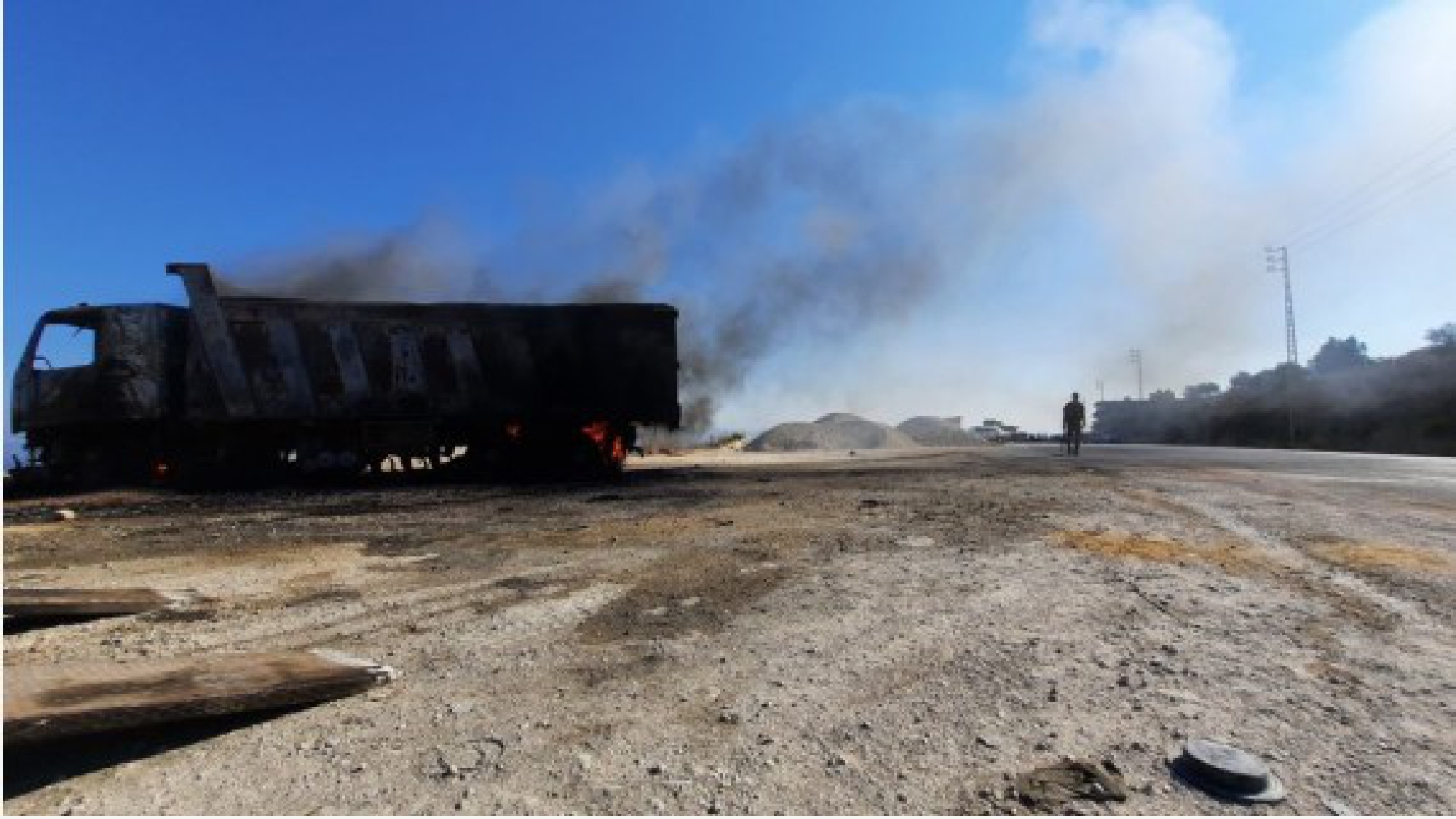 A truck is burned by angry youths near the site of the petrol tank explosion in Akkar, northern Lebanon, on August 15, 2021.