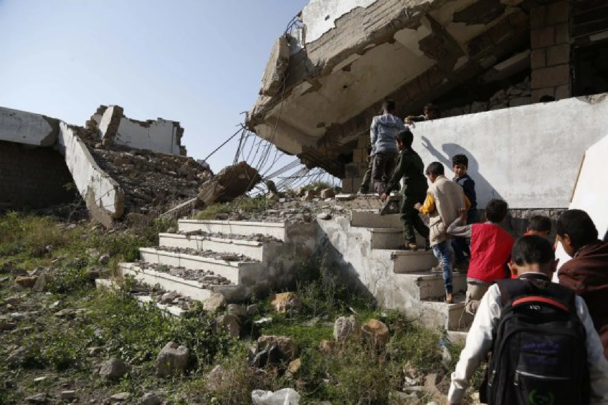 School children enter a half-collapsed teaching building at Shuhada-Alwahdah school in Al-Radhmah district in Ibb province, about 190 km south of the Houthi-held capital Sanaa, Yemen, on Aug. 14, 2021.