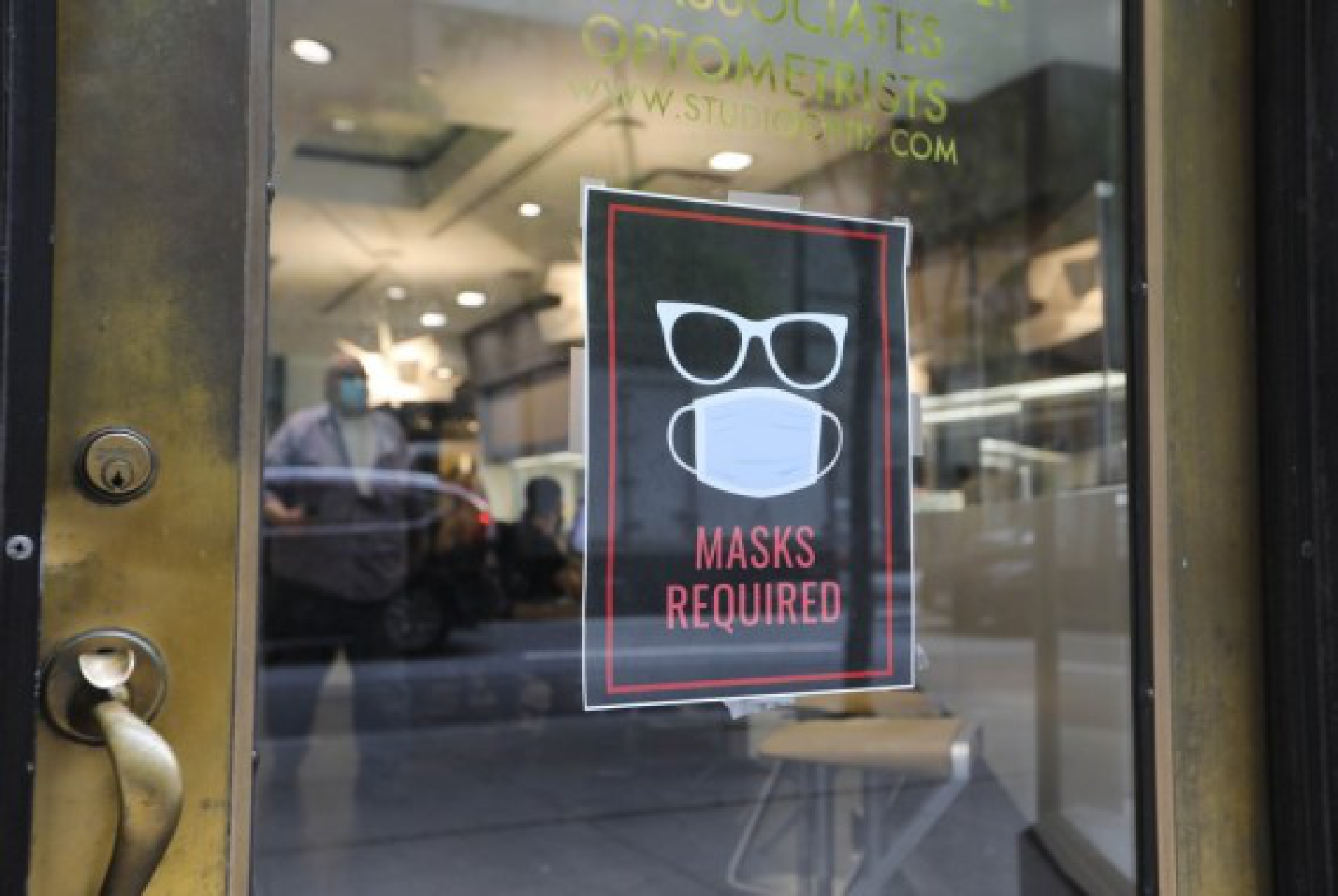 A sign is seen at the entrance to an optical shop in New York City, the United States, Aug. 2, 2021.