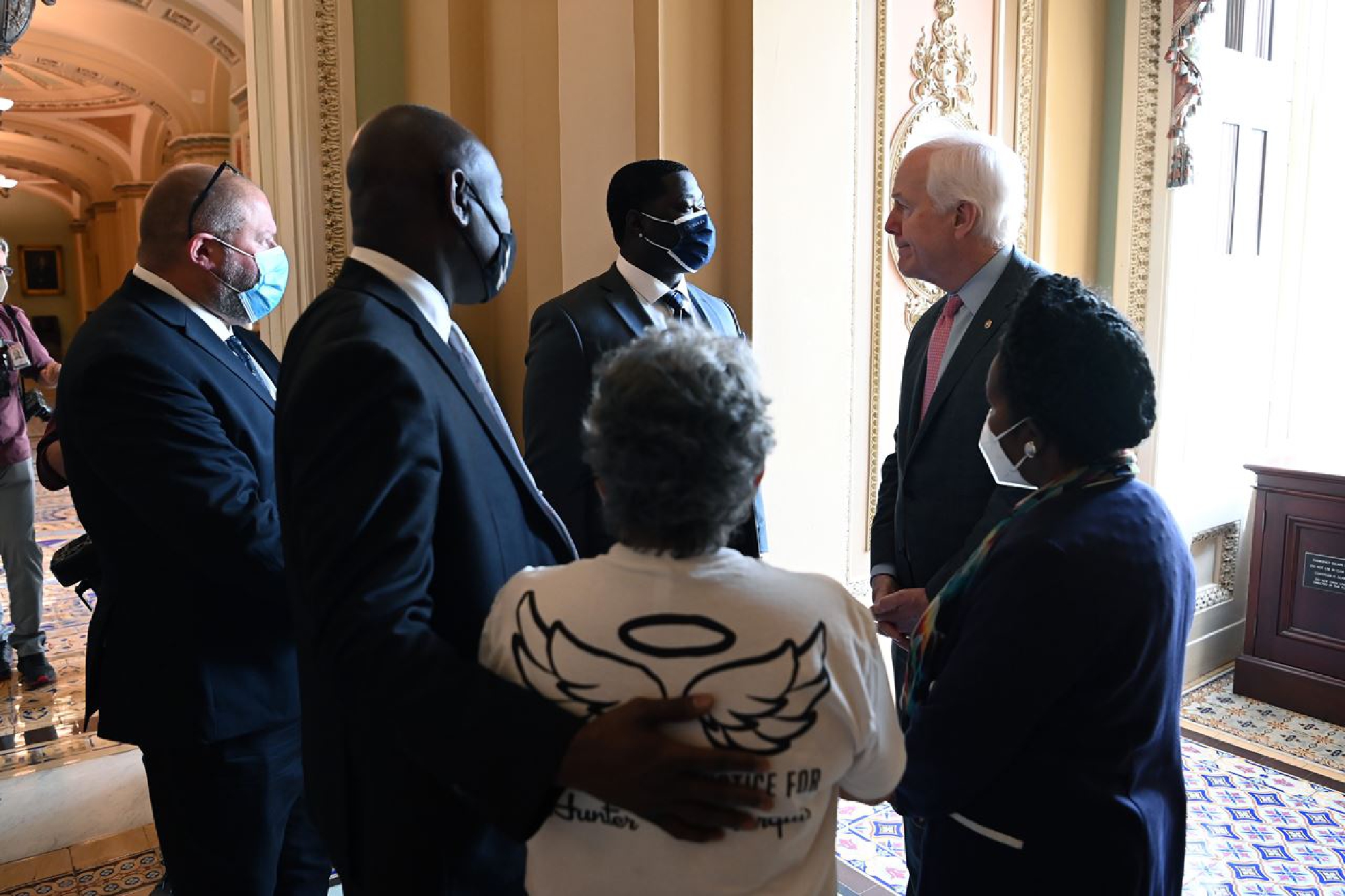 WASHINGTON, DC - AUGUST 03: Brandon Williams, center, who is the nephew of George Floyd speaks to Senator John Cornyn (R-TX) on Tuesday August 03, 2021 in Washington, DC. They were meeting with lawmakers for a police reform bill. MUST CREDIT: Photo by Matt McClain/The Washington Post