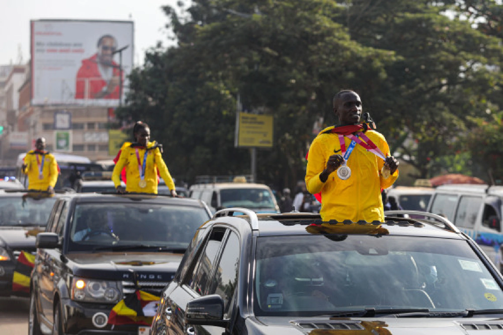 Joshua Cheptegei (R), who won gold in the men's 5,000m final and silver in the men's 10,000m at Tokyo Olympics, acknowledges greetings from crowds in Kampala, Uganda, Aug. 10, 2021.