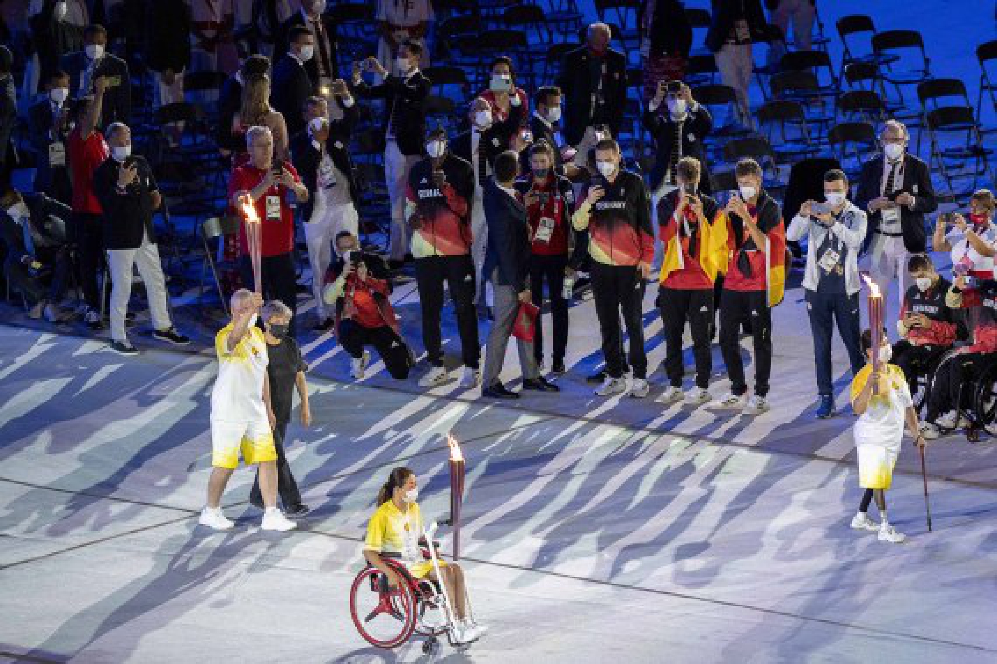 Torch bearers carry the Paralympic flame during the opening ceremony of Tokyo 2020 Paralympic Games in Tokyo, Japan, Aug. 24, 2021. 