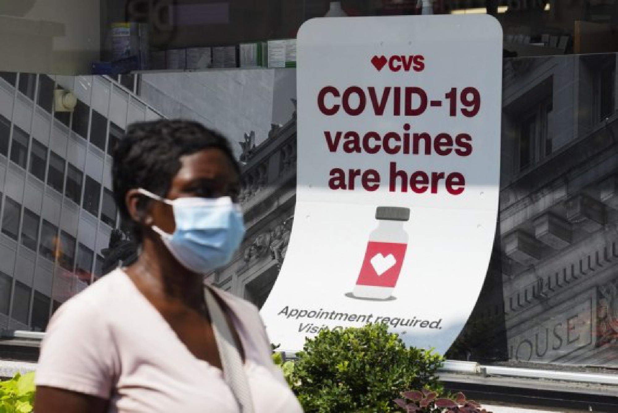 A man walks past a sign of COVID-19 vaccination at a pharmacy in New York, the United States, Aug. 11, 2021.