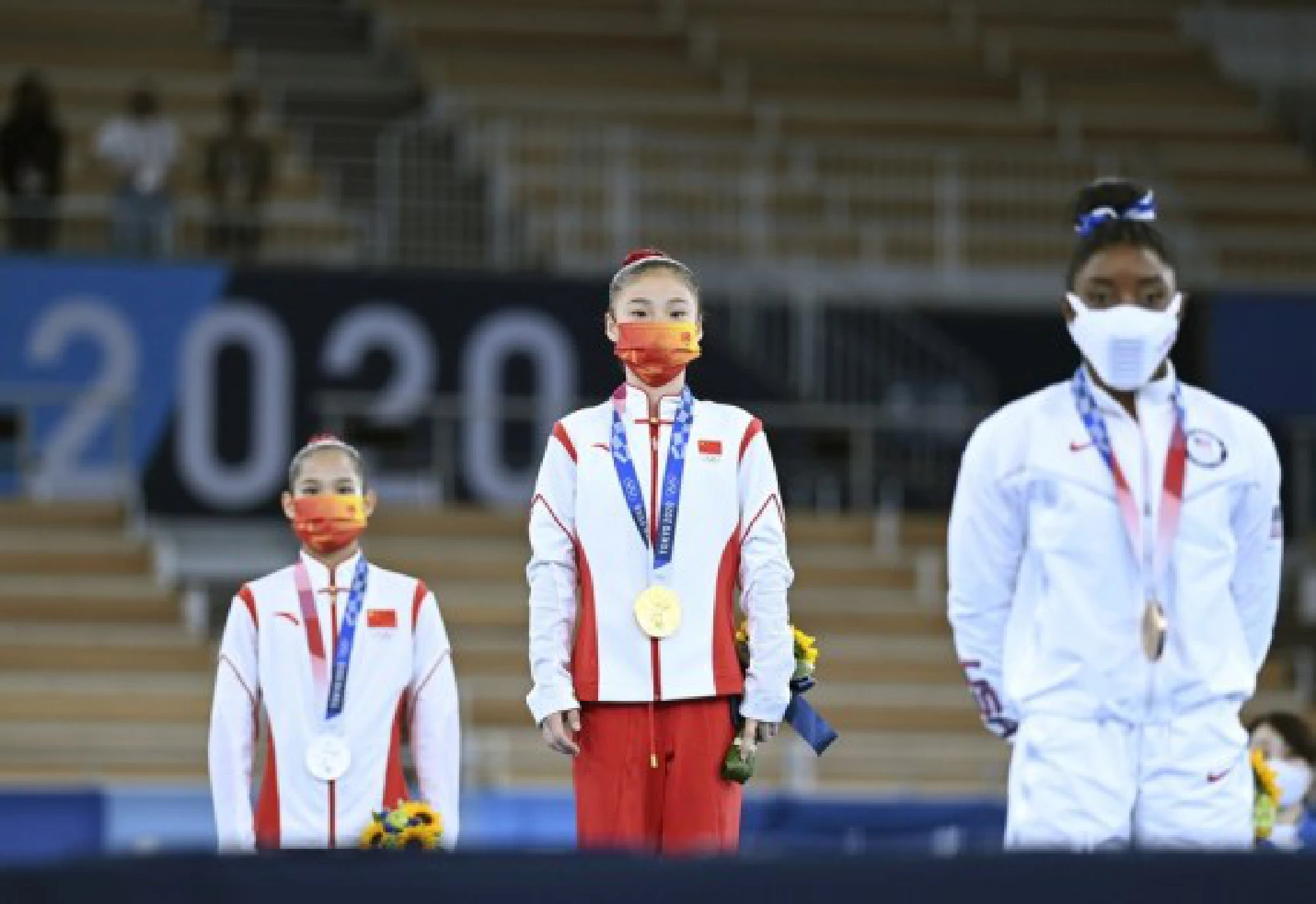 Guan Chenchen (C), Tang Xijing (L) of China and Simone Biles of the United States react during the awarding ceremony after the artistic gymnastics women's balance beam final at the Tokyo 2020 Olympic Games in Tokyo, Japan, Aug. 3, 2021.