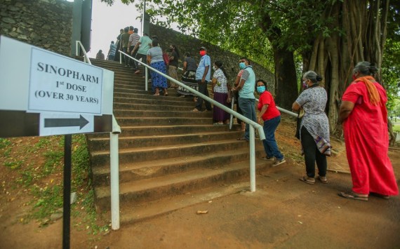 People stand in the queue at the Viharamahadevi Park in Sri Lanka's capital Colombo on Aug. 7, 2021, to receive the first doses of the Sinopharm vaccines.