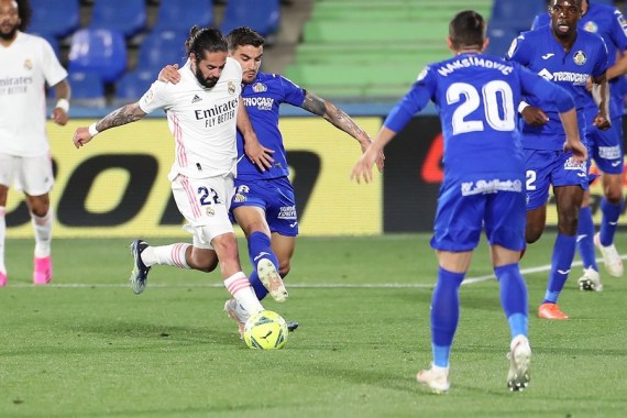 Real Madrid's Isco (1st L) vies with Getafe's Mauro Arambarri (2nd L) during their Spanish league football match in Getafe, Spain, on April 18, 2021.