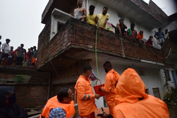 Members of the National Disaster Response Force (NDRF) distribute relief supplies among flood-affected people in Prayagraj district in India's northern state of Uttar Pradesh, Aug. 10, 2021. 