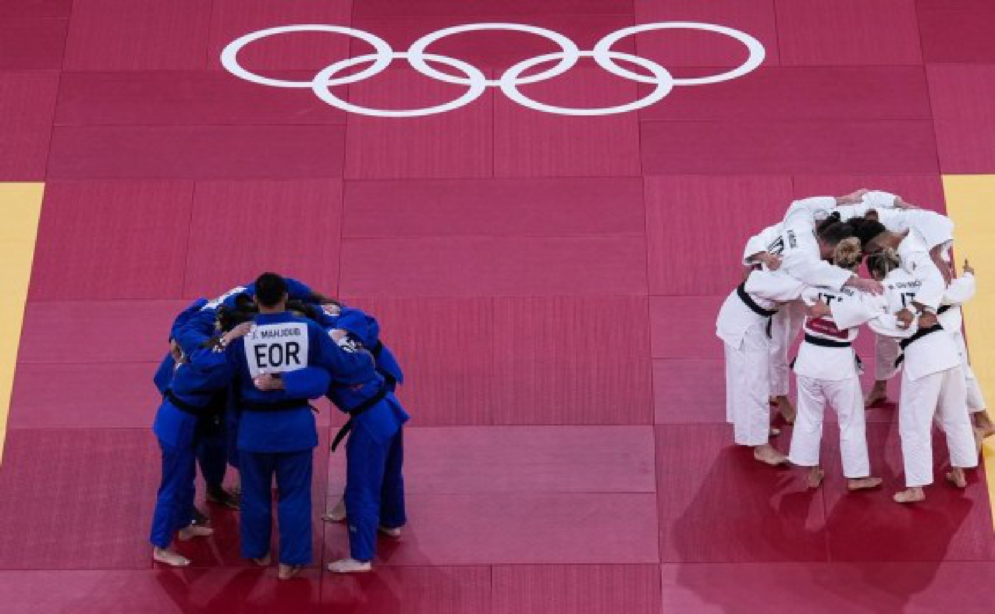 Refugee Olympic Team (L) and team Italy cheer up prior to the Judo mixed team event at the Tokyo 2020 Olympic Games in Tokyo, Japan, July 31, 2021.