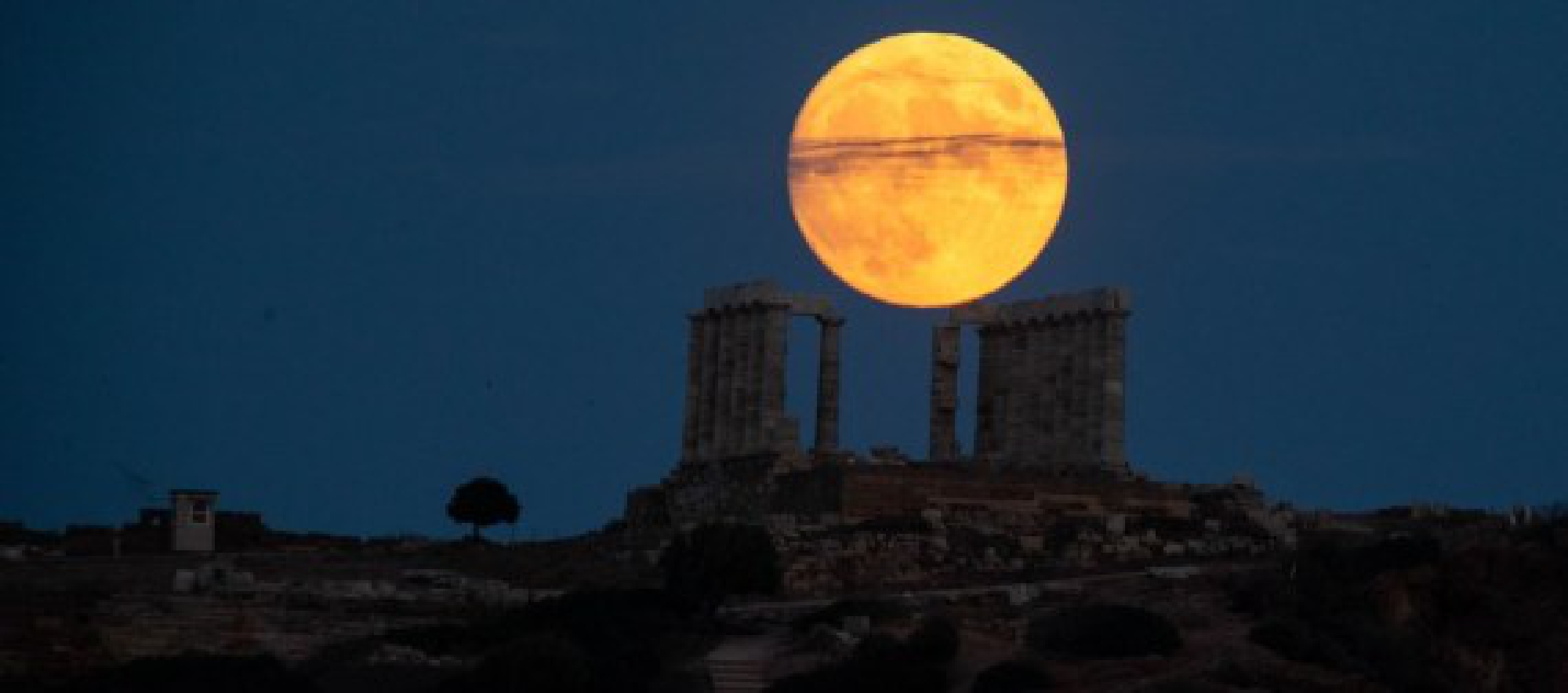 A full moon is seen over the Temple of Poseidon at cape Sounion, some 70 km southeast of Athens, Greece, on Aug. 21, 2021.