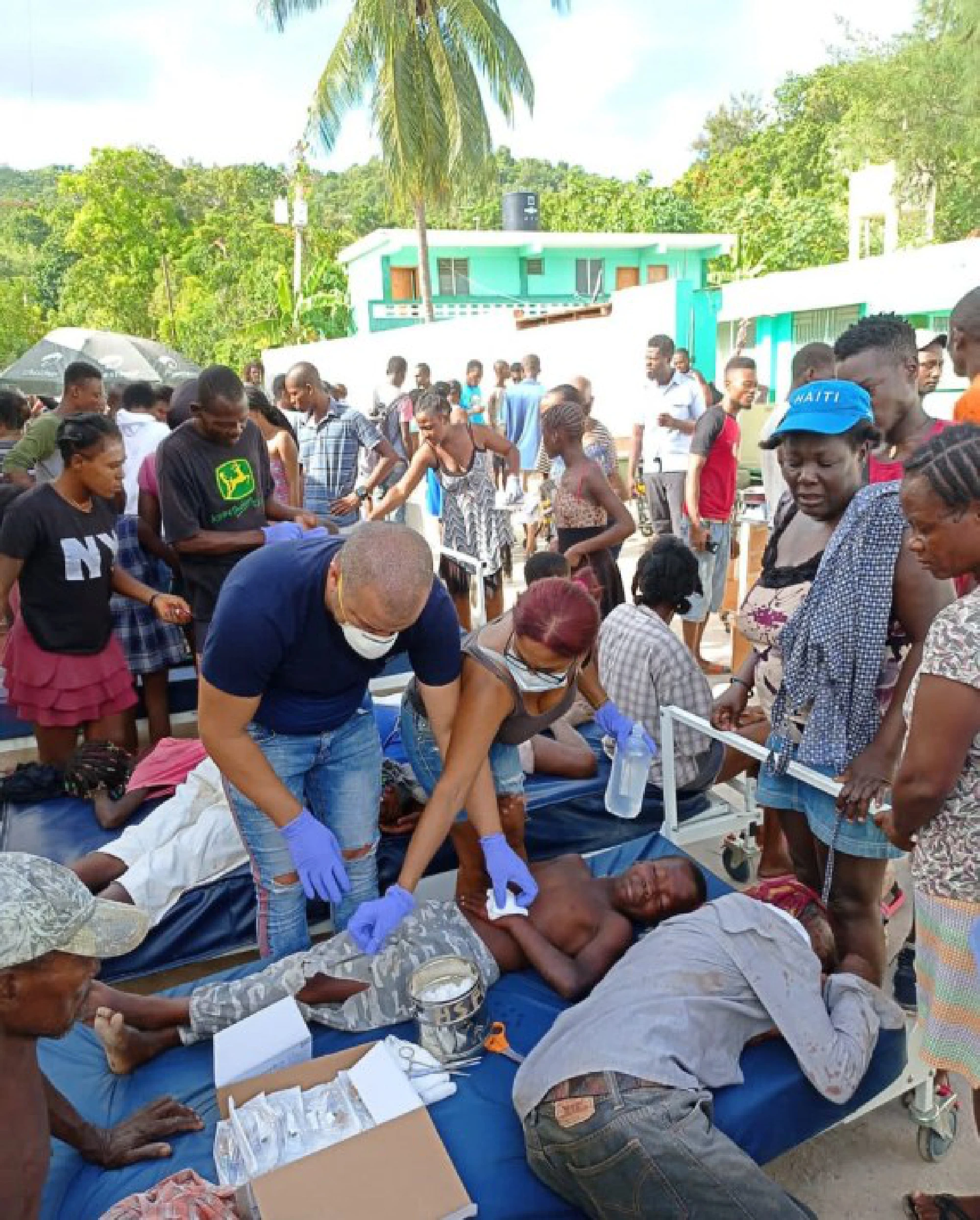Photo taken with a mobile device shows members of the Cuban Medical Brigade helping injured people after an earthquake in Jeremie, Haiti, Aug. 14, 2021.