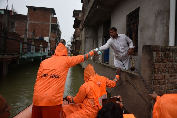 Members of the National Disaster Response Force (NDRF) distribute relief among flood affected people in Prayagraj district, India's northern state of Uttar Pradesh, Aug. 11, 2021.