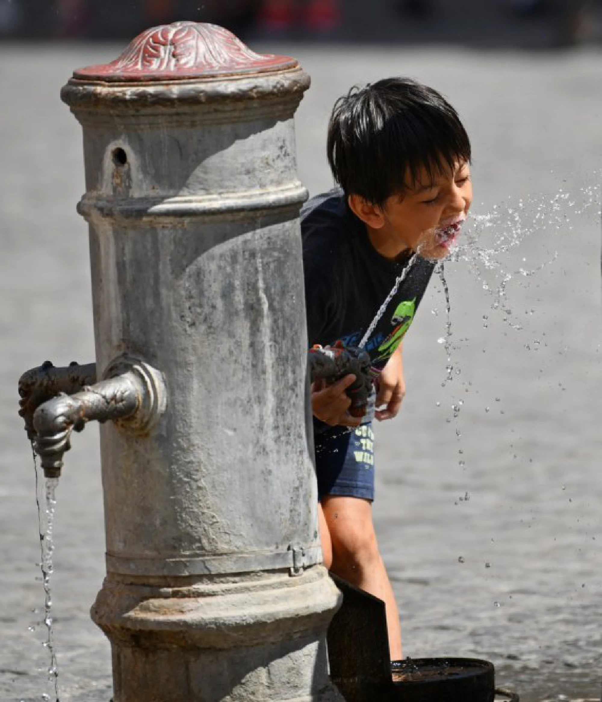 A boy refreshes himself with the tap water in Rome, Italy, Aug. 12, 2021.