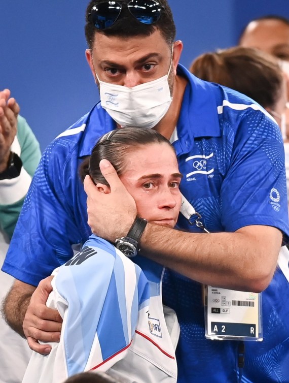 Oksana Chusovitina of Uzbekistan is consoled by her coach after the women's artistic gymnastics qualification round on July 25, 2021. 