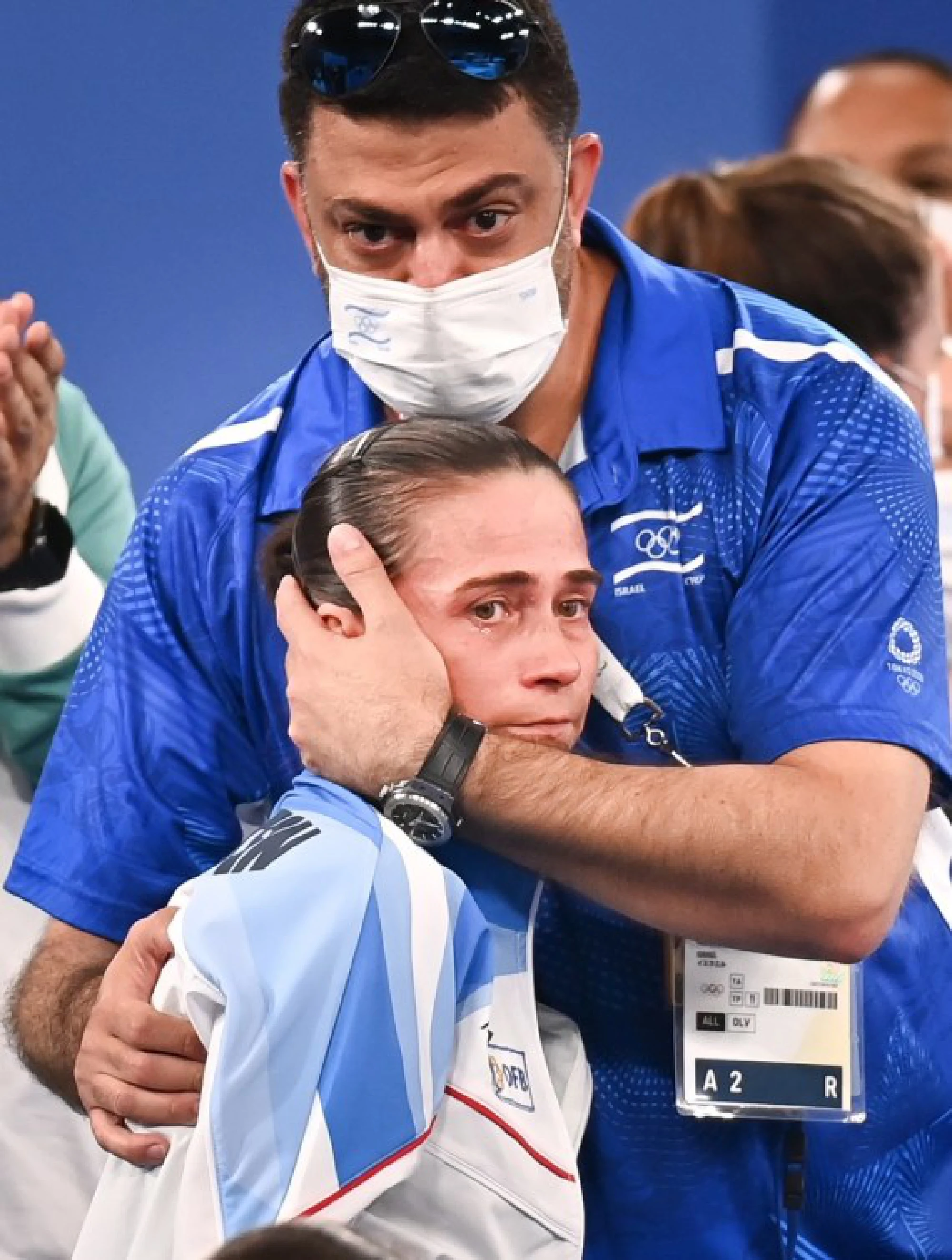 Oksana Chusovitina of Uzbekistan is consoled by her coach after the women's artistic gymnastics qualification round on July 25, 2021. 