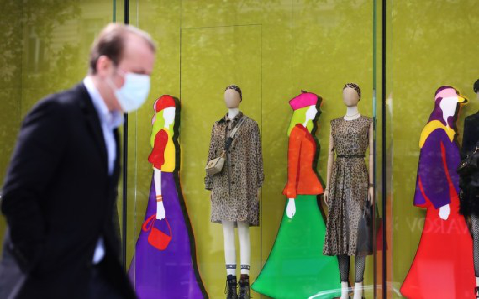 A man wearing a mask walks past a boutique at the Champs Elysees Avenue in Paris, France, May 12, 2021.