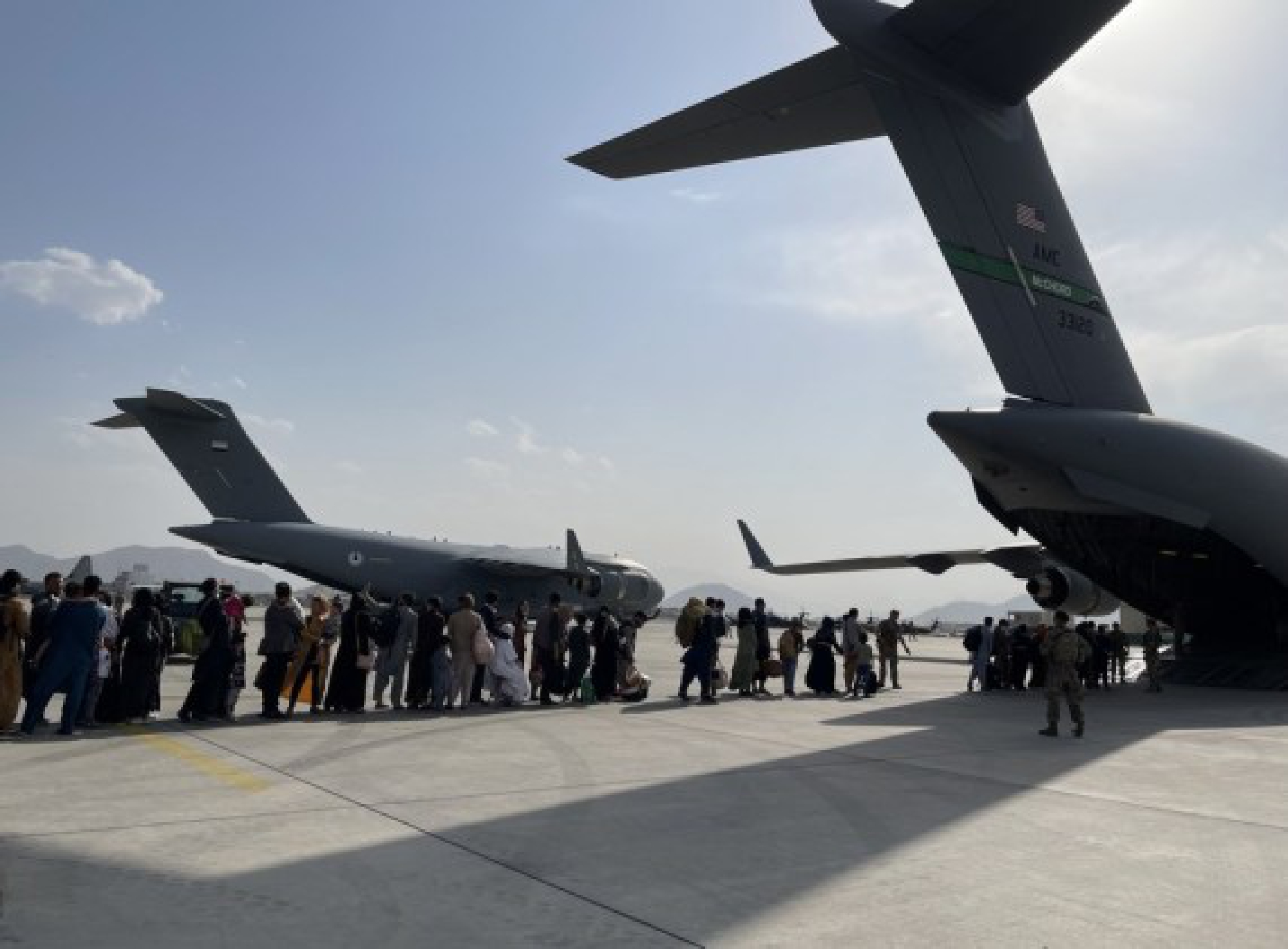 People queue up to board a military aircraft of the United States and leave Kabul at Kabul airport, Afghanistan, Aug. 22, 2021. 