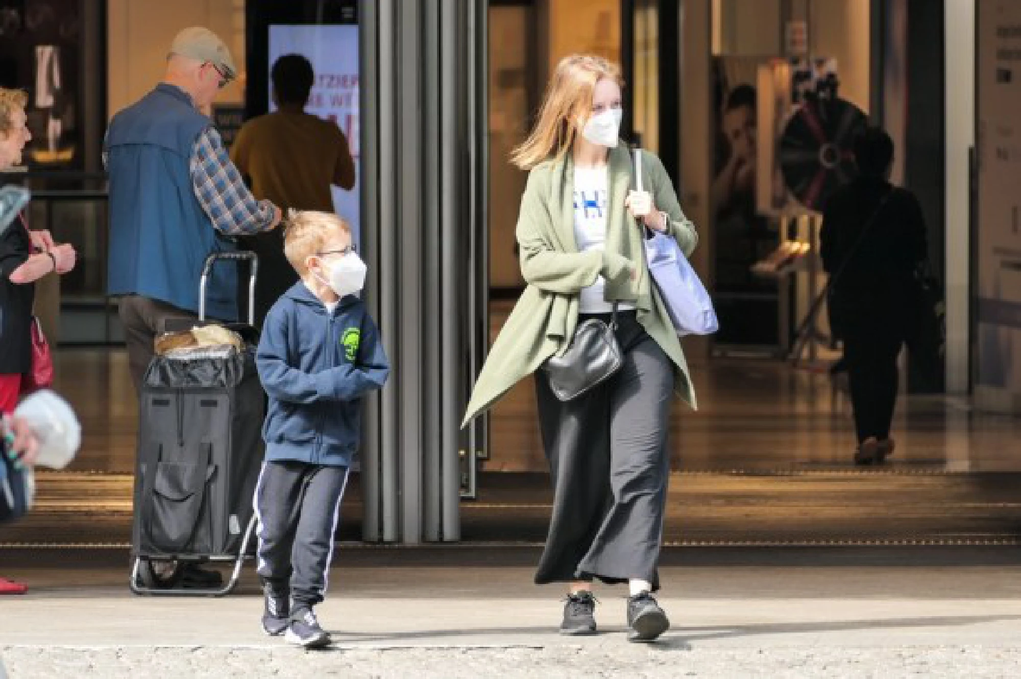 Customers wearing face masks walk out of a store in Berlin, capital of Germany, on Aug. 5, 2021.  