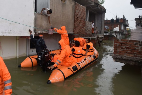 Members of the National Disaster Response Force (NDRF) distribute relief among flood affected people in Prayagraj district, India's northern state of Uttar Pradesh, Aug. 11, 2021.