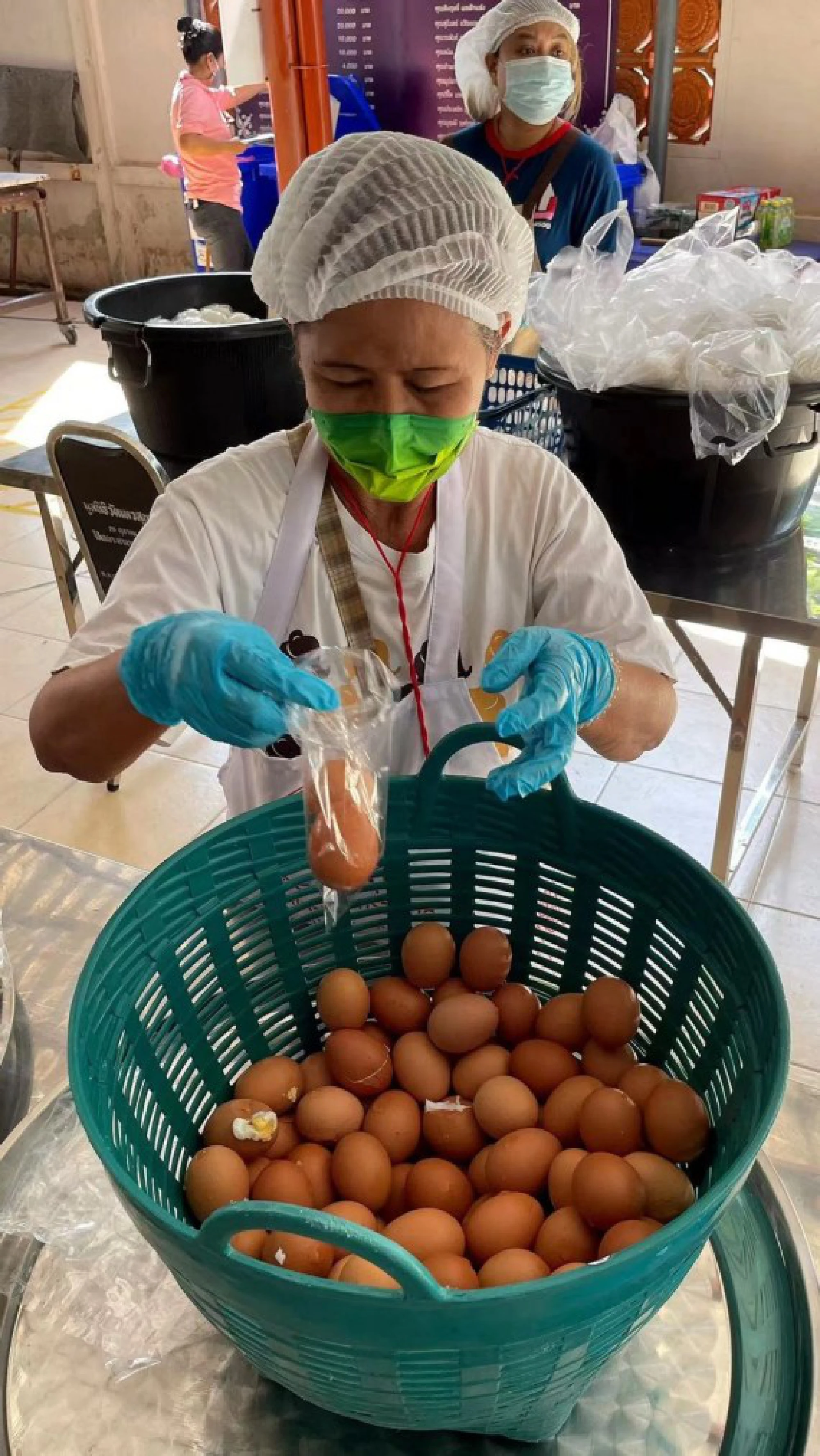 Photo taken on June 8, 2021 shows a volunteer of the Up for Thai packing eggs in a temporary kitchen set up in a temple in northern Bangkok, Thailand. 