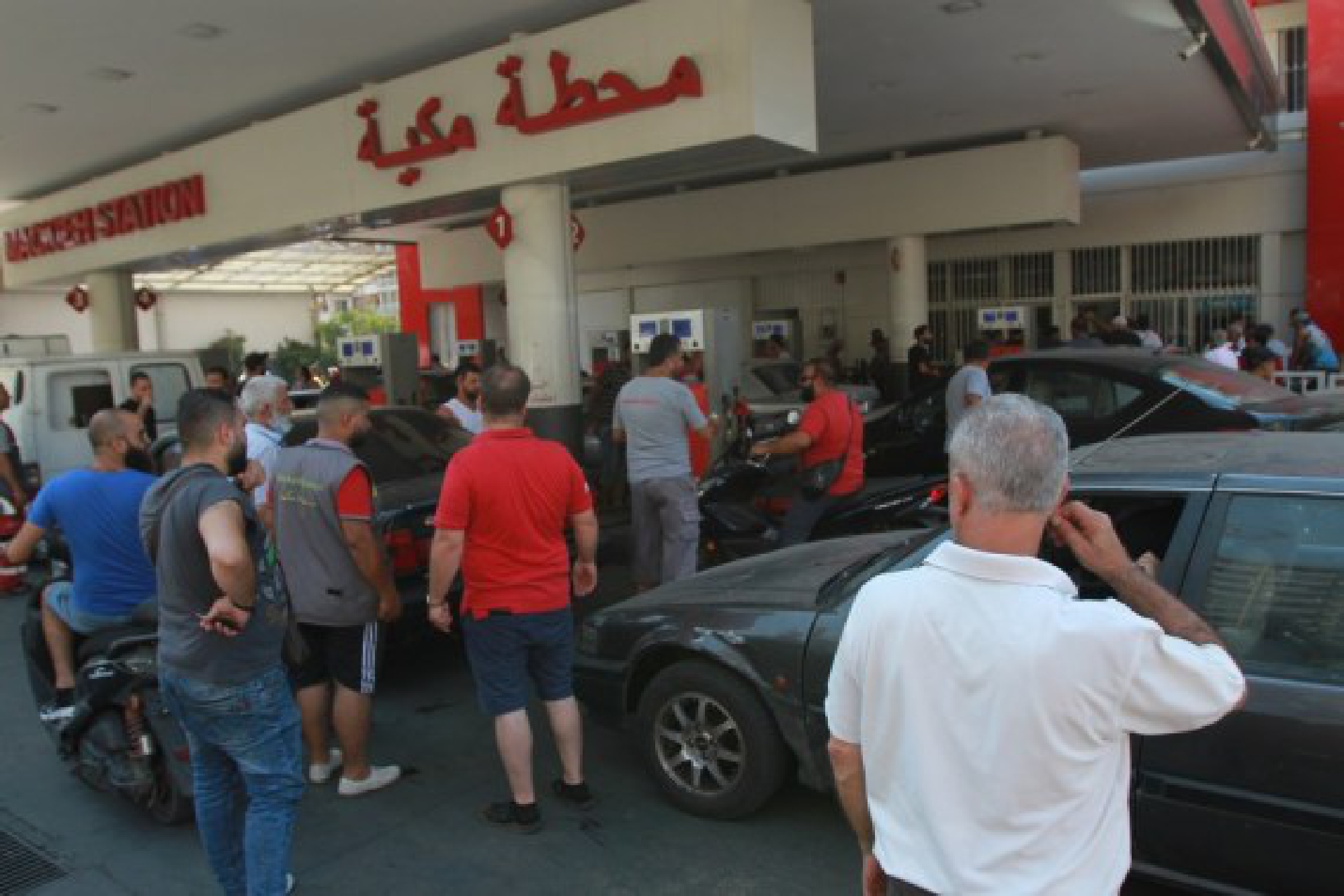 People wait to fill gasoline at a gas station in the city of Tripoli, northern Lebanon, on Aug. 12, 2021. 