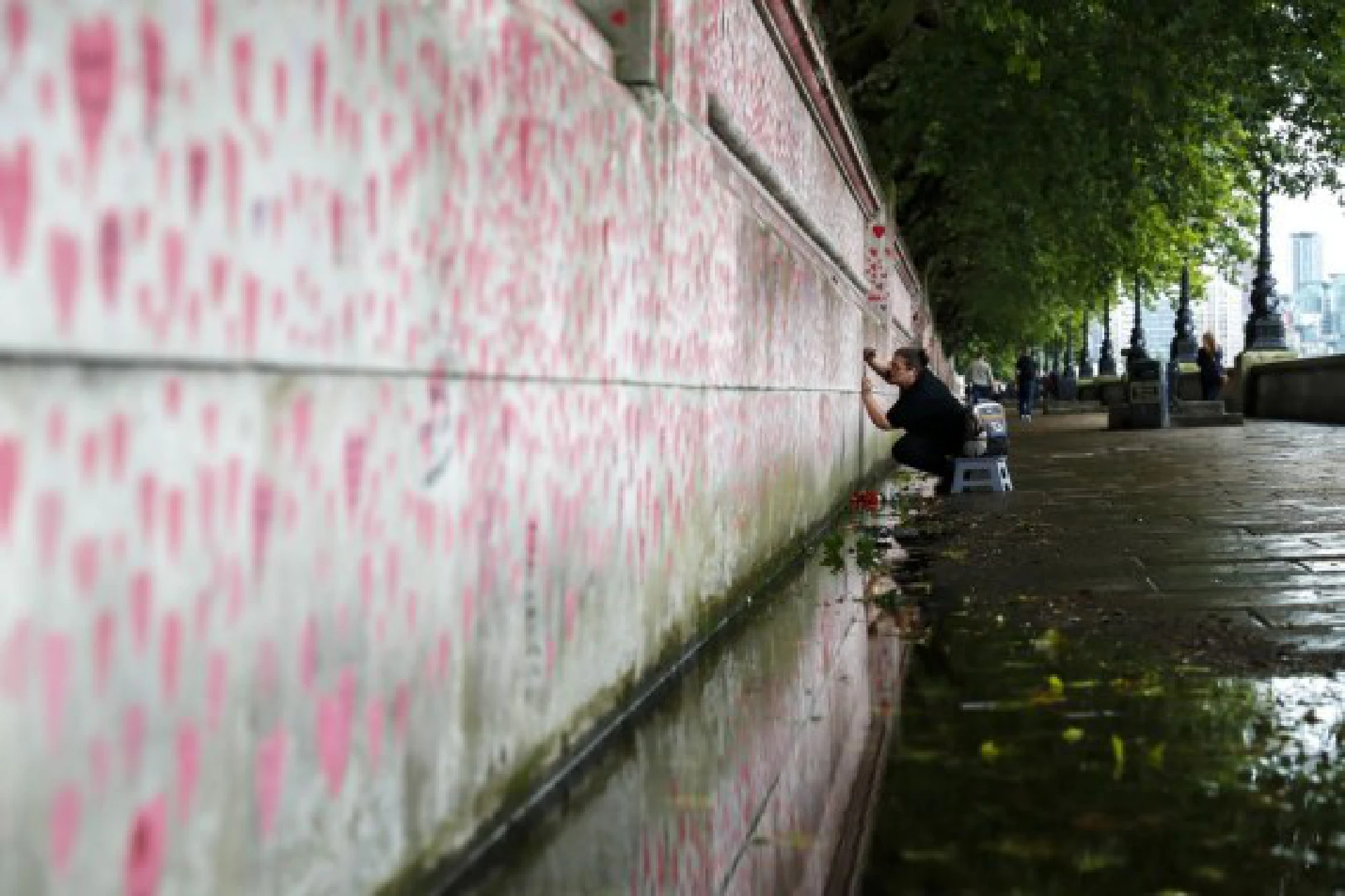  A woman draws a red heart on the National COVID Memorial Wall in London, Britain, Aug. 9, 2021.