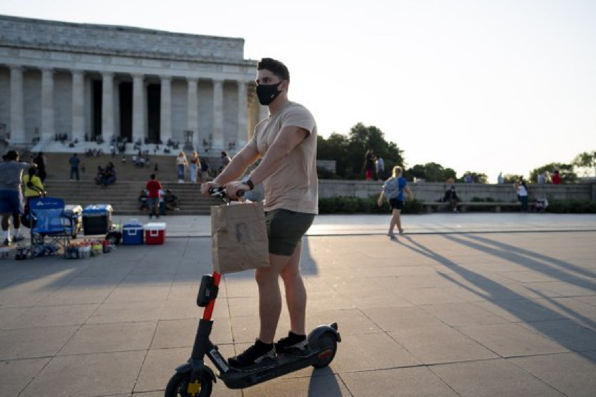 A man wearing a mask rides an electric scooter near the Lincoln Memorial in Washington, the United States, Aug. 4, 2021.
